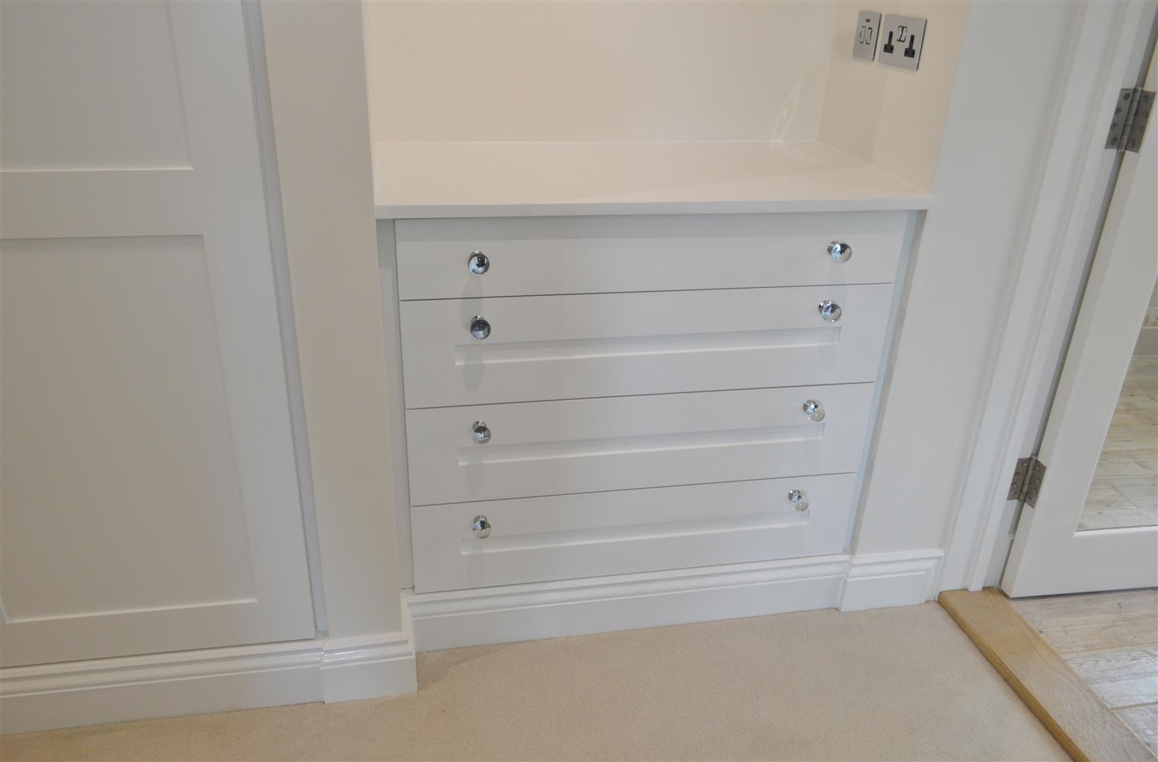 This set of drawers fills the alcove well to provide storage and worktop space. Incorporating the skirting into the design adds to its built-in effect.